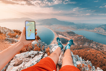 Young and sportive man on top of a mountain with a stunning view of the Iztuzu beach in Turkey and...