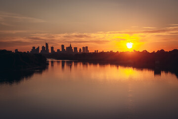 Obraz premium Vistula River and city downtown in Warsaw, capital of Poland - sunset view from Siekierkowski Bridge