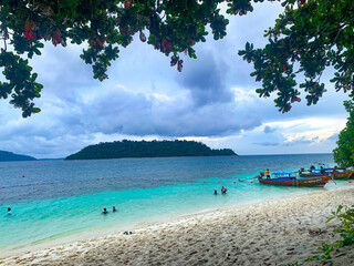 Tourist enjoy beautiful paradise beach with white sand, turquoise water at Lipe Island, Satun, Thailand.