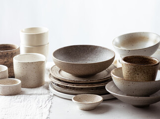 handmade ceramic tableware, empty craft ceramic plates, bowls and cups on light background 