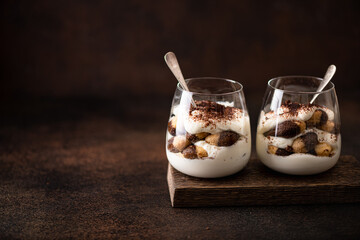 tiramisu dessert in a glass on a dark background, copy space