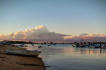 Atardecer sobre la ria de Punta Umbria barcos de pesca y tormenta en lalejania 