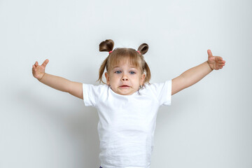 emotional little girl on a light flat background. the child spread his arms to the side. a symbol of great benefit. layout for design with place for text. space for text and copy space