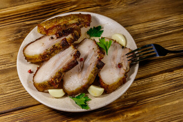 Baked pork belly in a plate on wooden table