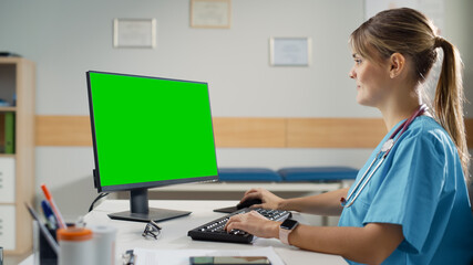 Hispanic Doctor's Office: Experienced Head Nurse Sitting at Her Desk Working on Green Chroma Key Screen Personal Computer. Medical Health Care Specialist Checking Test Results, Prescribing Medicine.