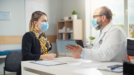 Hispanic Doctor Consultation Office: Patient Listens to Physician who Uses Digital Tablet Computer...
