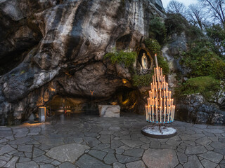 The Grotto of Massabielle is the place where the Virgin appeared to Bernadette Soubirous, a 14-year-old girl, from Lourdes, France, in 1858. At the back left of the Grotto is the Spring. - obrazy, fototapety, plakaty