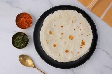 Rice bhakri, Chawal ki roti. It is a round soft flatbread. Usually eaten with fish, chicken or mutton thali. Served with garlic & green chutney. Copy space.