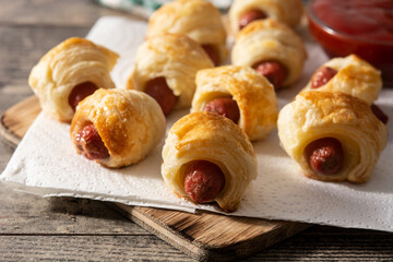 Pigs in blankets. Mini sausages wrapped in puff pastry with ketchup sauce. 