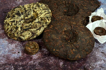 Pressed round pancakes and bricks of puer tea of different kinds. Dry Chinese puer tea of high quality.
