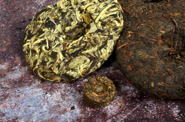 Pressed round pancakes and bricks of puer tea of different kinds. Dry Chinese puer tea of high quality.