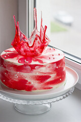red bright holiday cake with caramel decoration on the windowsill