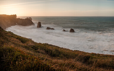 Panoramic landscape of the Arnía beach in a beautiful sunset at high tide