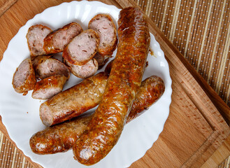 Homemade fried sausages in a white plate. Top view.