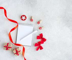 White blank notepad and Christmas red decor on gray background with copy space - 393565453