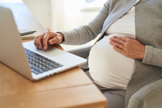 Schwangere Frau beim Arbeiten mit Laptop
