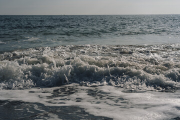 Small wave crashing in the sea on a cold autumn day