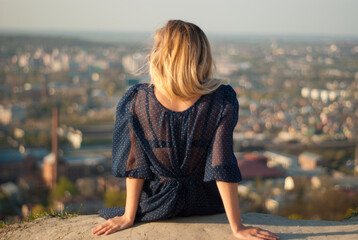Girl with blond hair looking from top view. travel and wanderlust concept. Young girl is sitting...