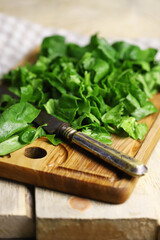 Sliced spinach on a wooden cutting board. Fresh juicy spinach for cooking.