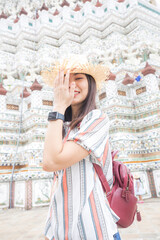 Pretty young asian backpack woman walking in the famous temple in Bangkok.