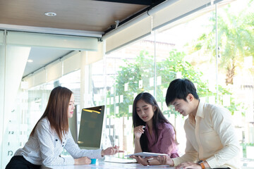 Cropped shot of two UI developers meeting on their project with paperwork and tablet on meeting...