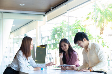 Cropped shot of two UI developers meeting on their project with paperwork and tablet on meeting...