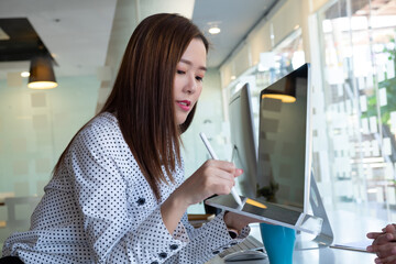 Cropped shot of two UI developers meeting on their project with paperwork and tablet on meeting...