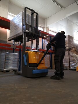Magasinier transportant des palettes &agrave; l'entrep&ocirc;t