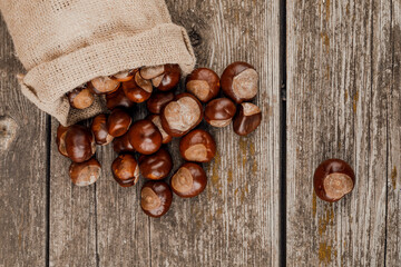 Fototapeta premium Chestnuts on an old wooden table