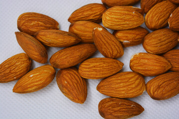 Delicious and healthy brown nuts, almonds, almonds set on a white matte background.
