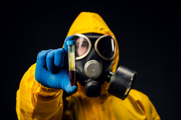 A male doctor or biologist wearing a protective suit to fight a pandemic or coronavirus. She's...