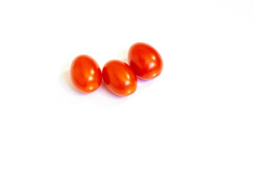 Three red cherry tomatoes isolated on a white background