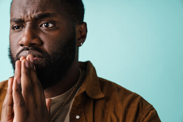 Focused african american man posing with palms together