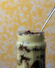 delicious vanilla custard with chocolate sponge cake pieces in a glass jar 