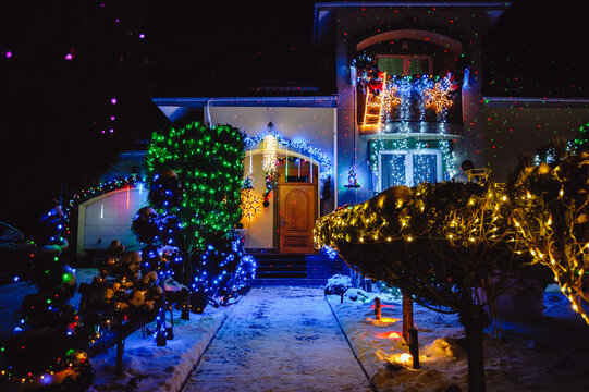 The house is decorated with Christmas holiday lights and decorations, including Santa and Christmas trees illuminated at night