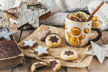 Cup with mulled wine or punch or spiced tea with christmas cookies, harmonious light colors, christmas or winter coffee break