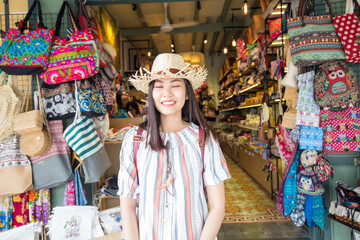 Woman travel in Bangkok city enjoy shopping in souvenir shop weekend market