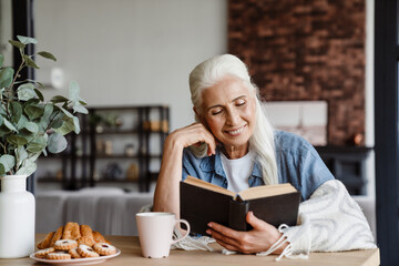 Smiling senior woman reading a book