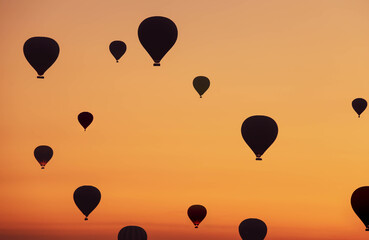 Obraz premium Selective focus on hot air balloons flying over the valley at Cappadocia. Hot air balloons are traditional touristic attraction in Cappadocia.