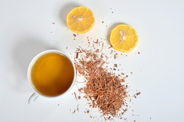 Cup of tea, Catuaba bark and lemon on white background. Natural herbal tea from Catuaba tree bark, natural aphrodisiac from Brasilia
