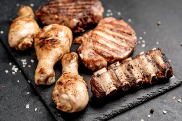 Various types of grilled meat, beef, pork, chicken on stone background	