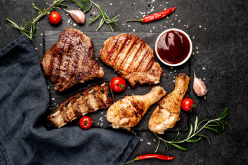 Various types of grilled meat, beef, pork, chicken on stone background