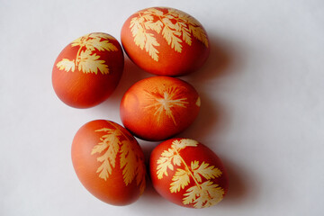 Painted Easter eggs on a white background. Floral pattern on a red eggshell. Festive food.