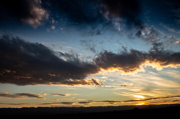 Shocking sunset between the field. Landscape with distant mountains during sunset.