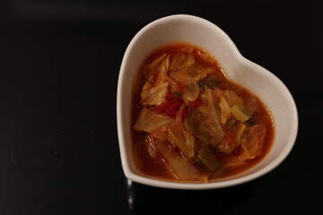 白いハートの器に入った健康的な野菜スープ	