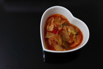 白いハートの器に入った健康的な野菜スープ	