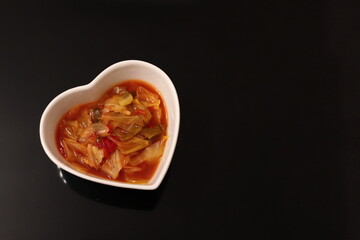 白いハートの器に入った健康的な野菜スープ