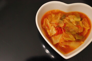 白いハートの器に入った健康的な野菜スープ	