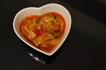 白いハートの器に入った健康的な野菜スープ	