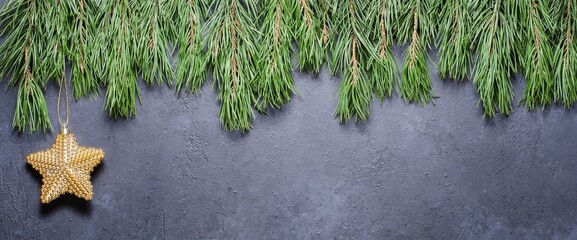 Pine branches and a star on a gray concrete background. The concept of Christmas and the New year. Copy space